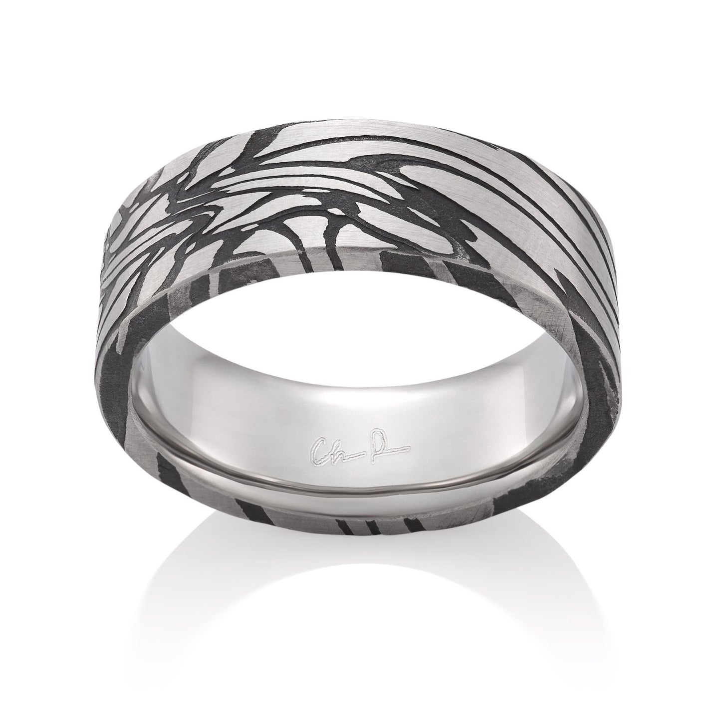 Silver ring with a textured, patterned surface on a white background