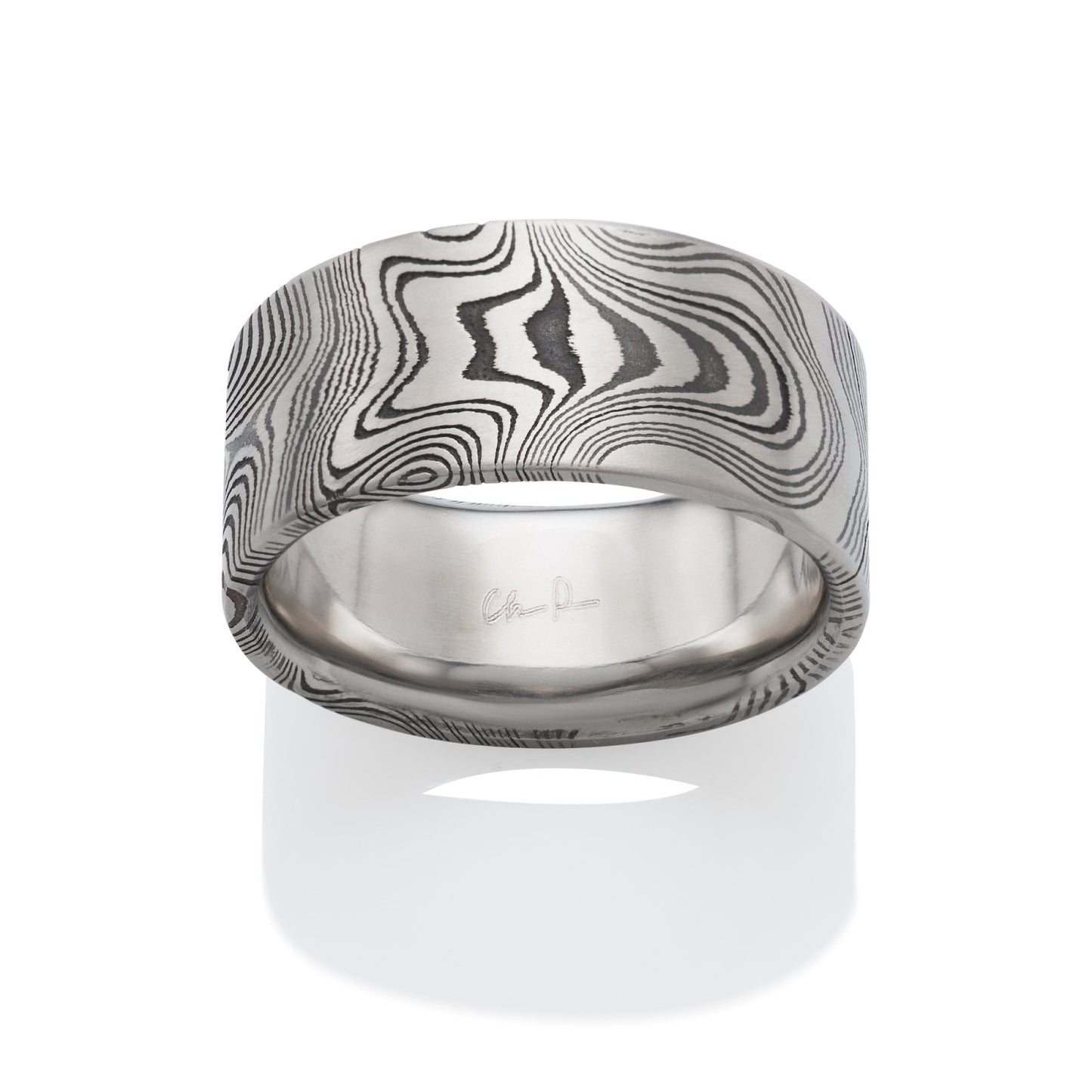 Damascus steel pattern band ring on a white background.