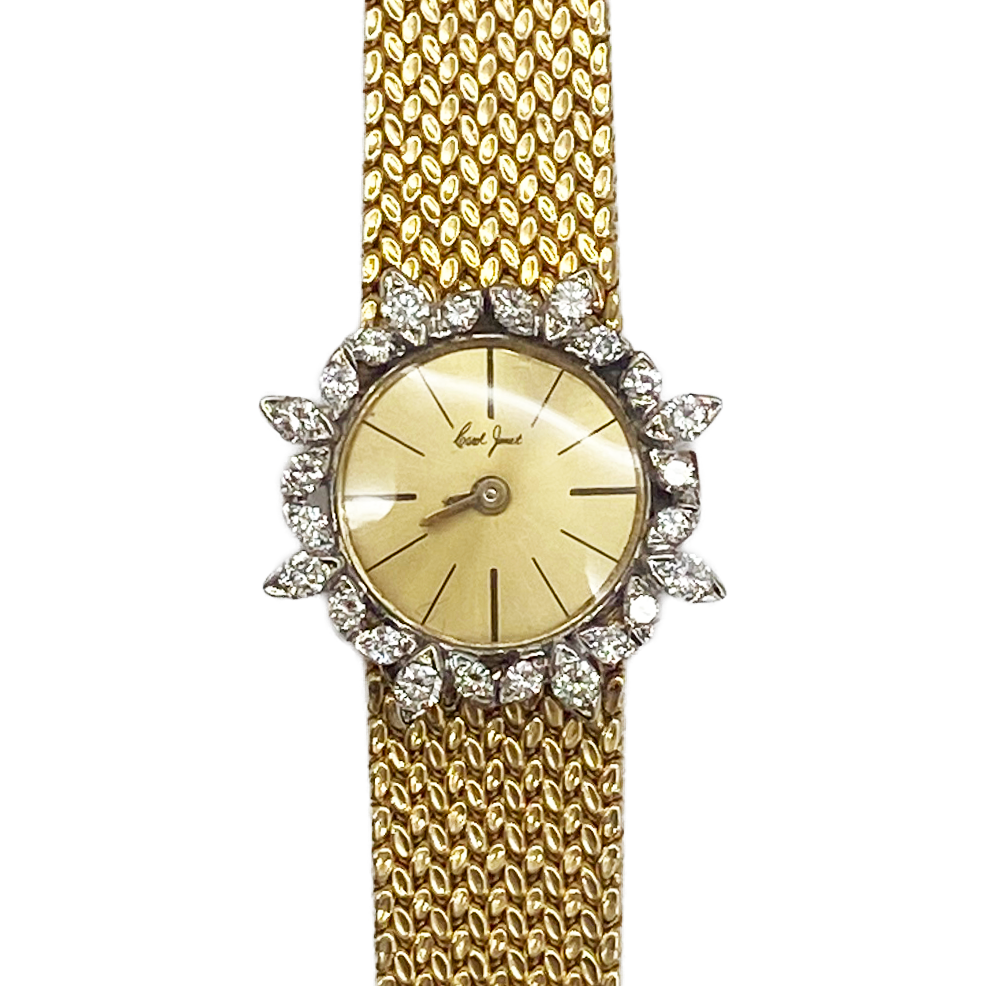 Gold watch with diamond-studded bezel on a white background