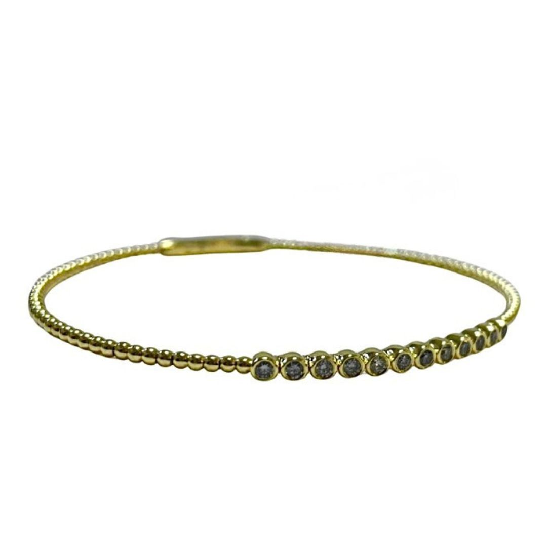 Gold bracelet with small black stones on a white background