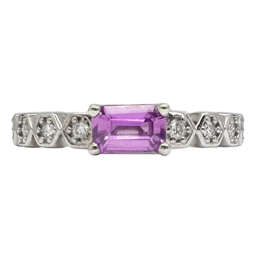 Silver ring featuring an emerald-cut pink sapphire flanked by  diamond