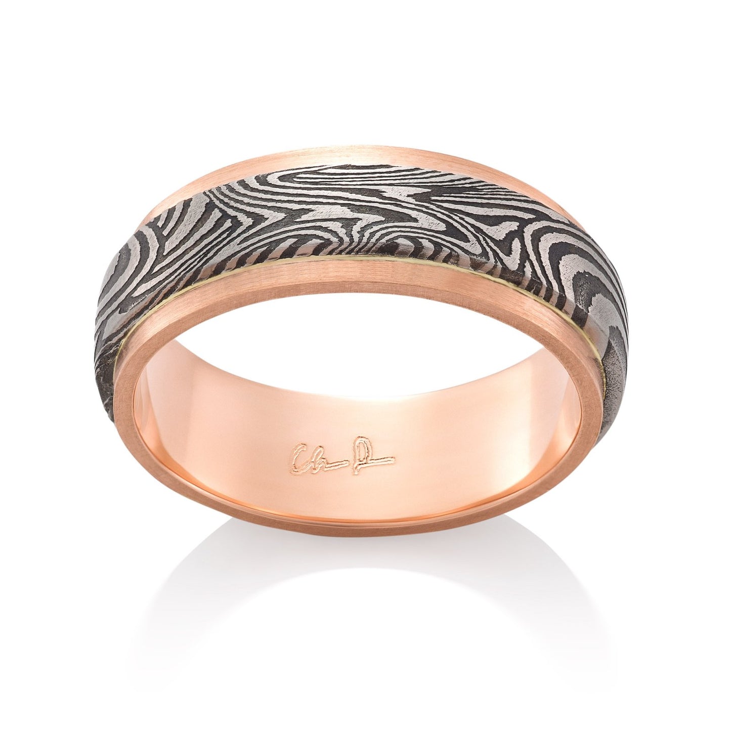 Rose gold ring with a Damascus steel inlay on a white background