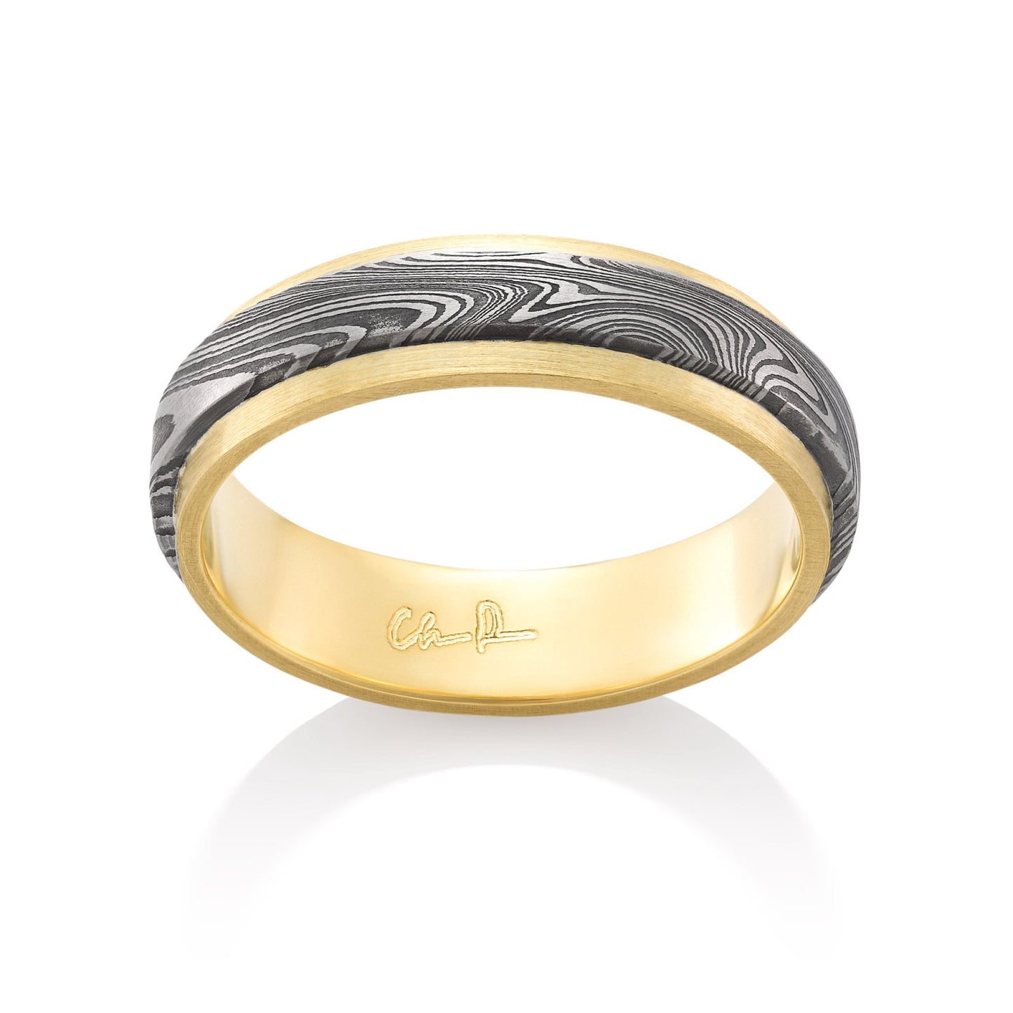 Yellow gold ring with a Damascus steel inlay on a white background