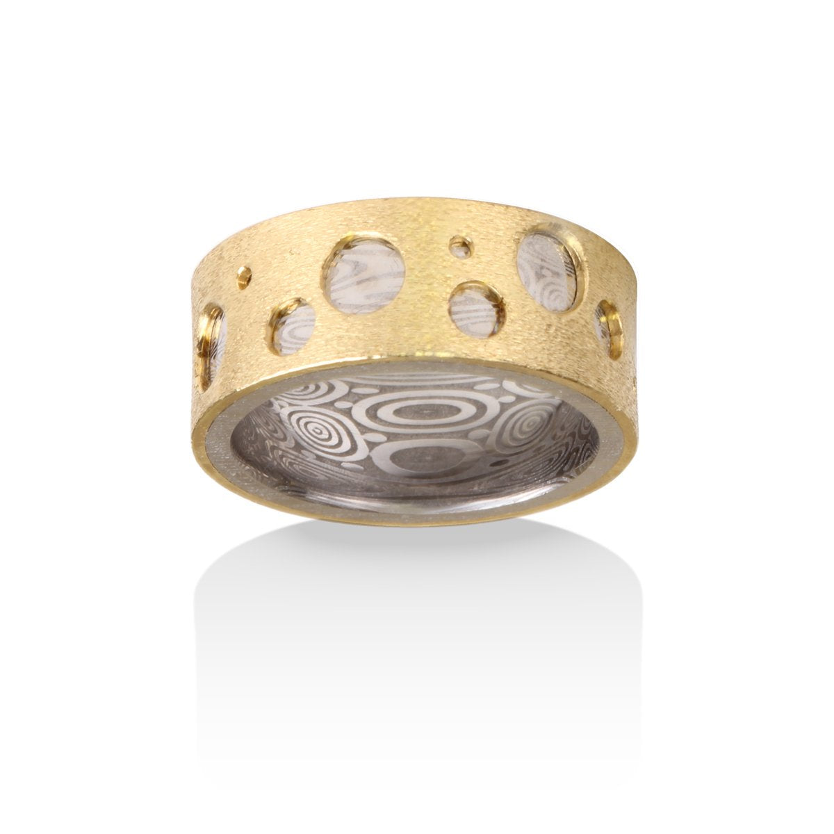 Two-tone gold ring with a textured pattern and cut-out circles on a white background.