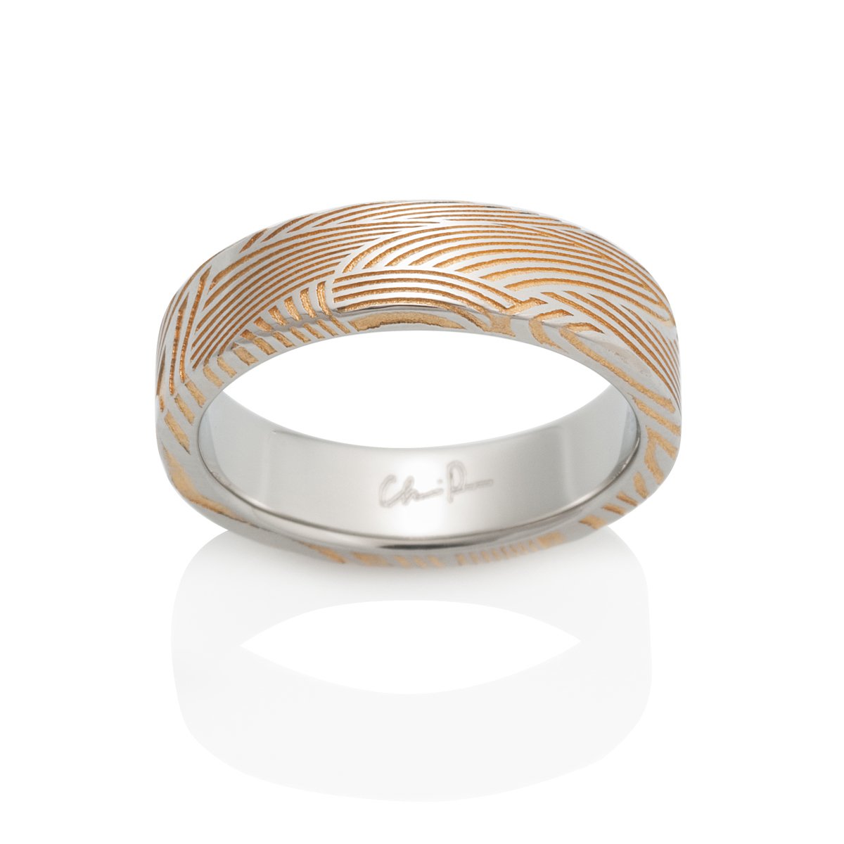 Two-tone gold ring with a textured pattern on a white background.