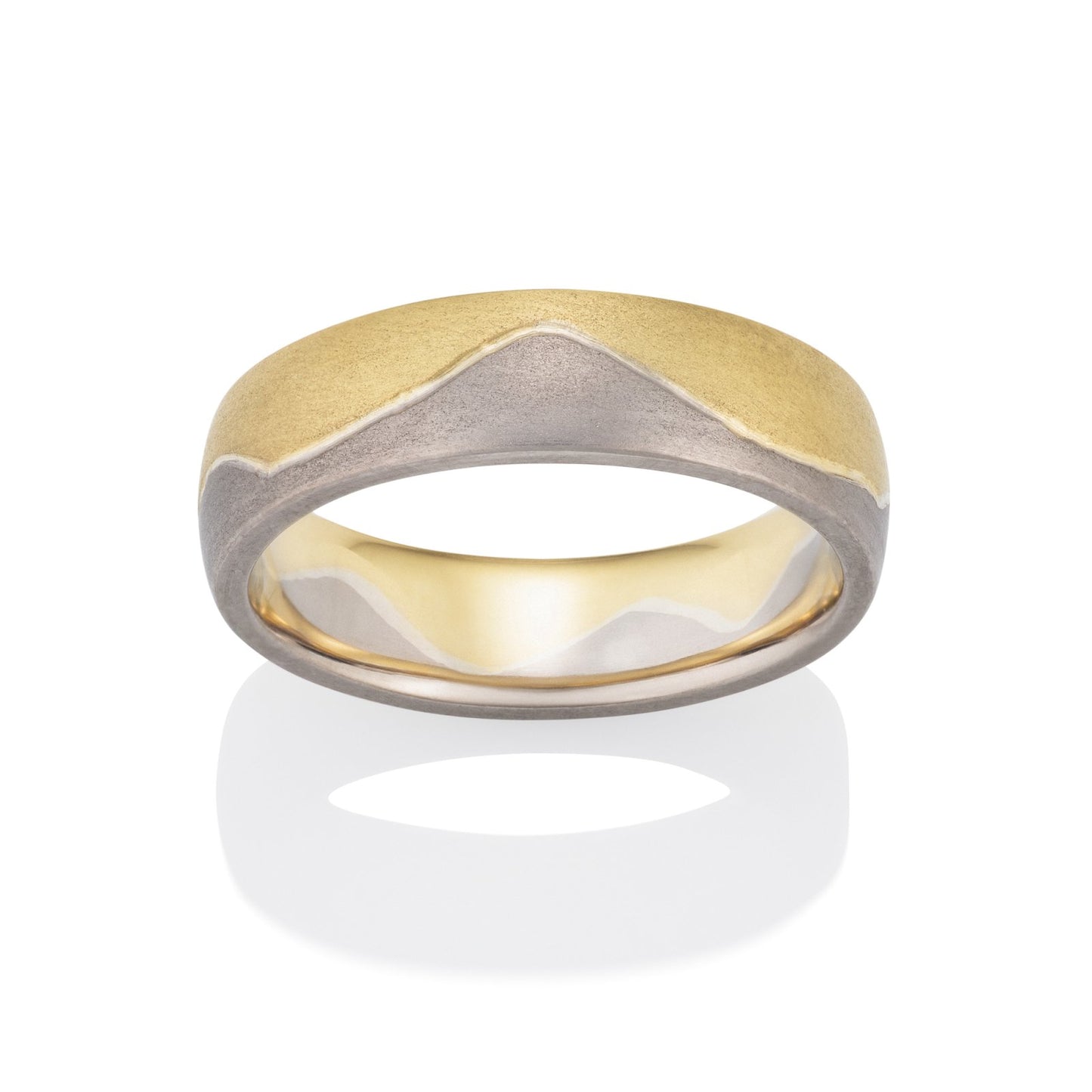 Two tone silver ring with a patterened design on a white background.