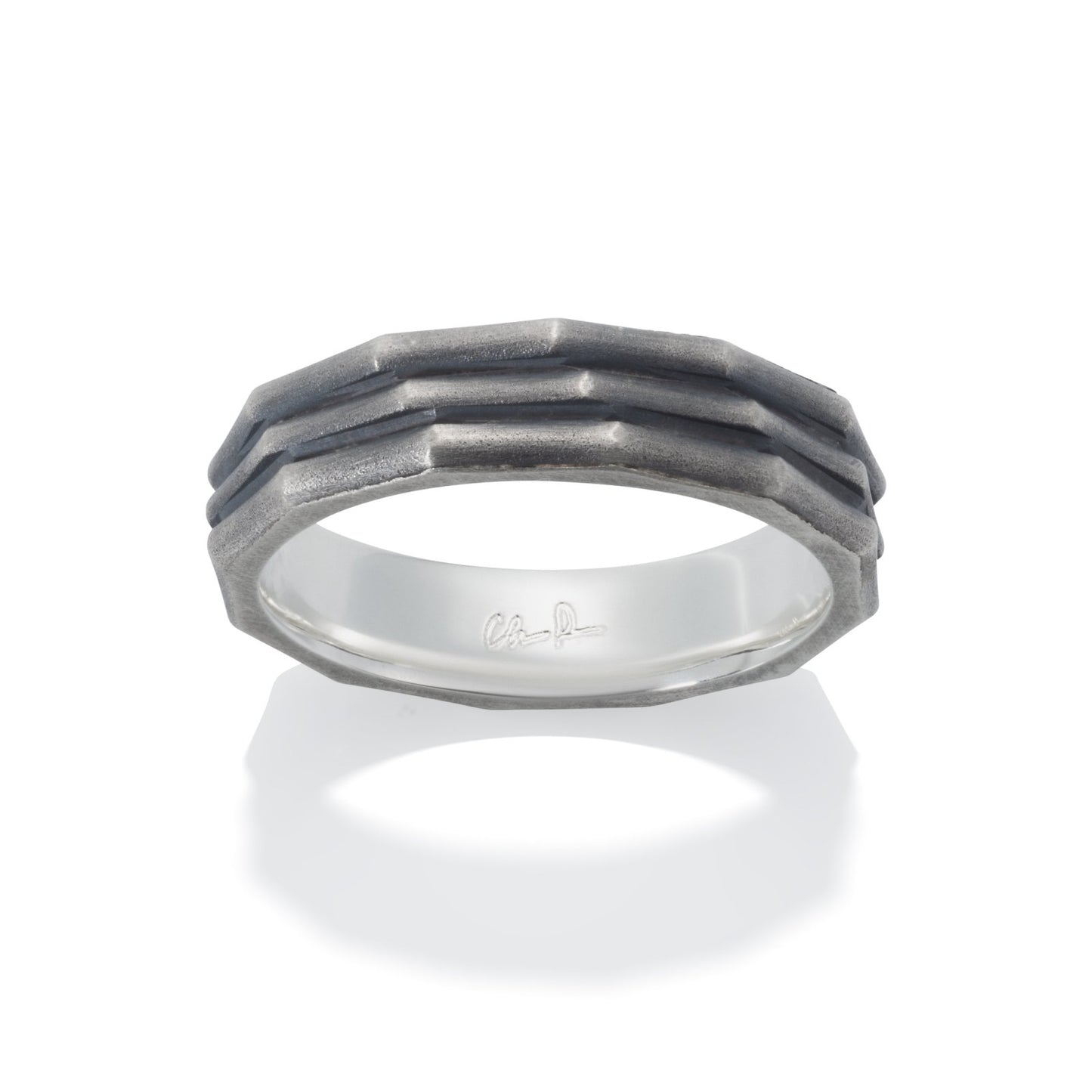 Silver ring with a textured, geometric pattern on a white backgroun