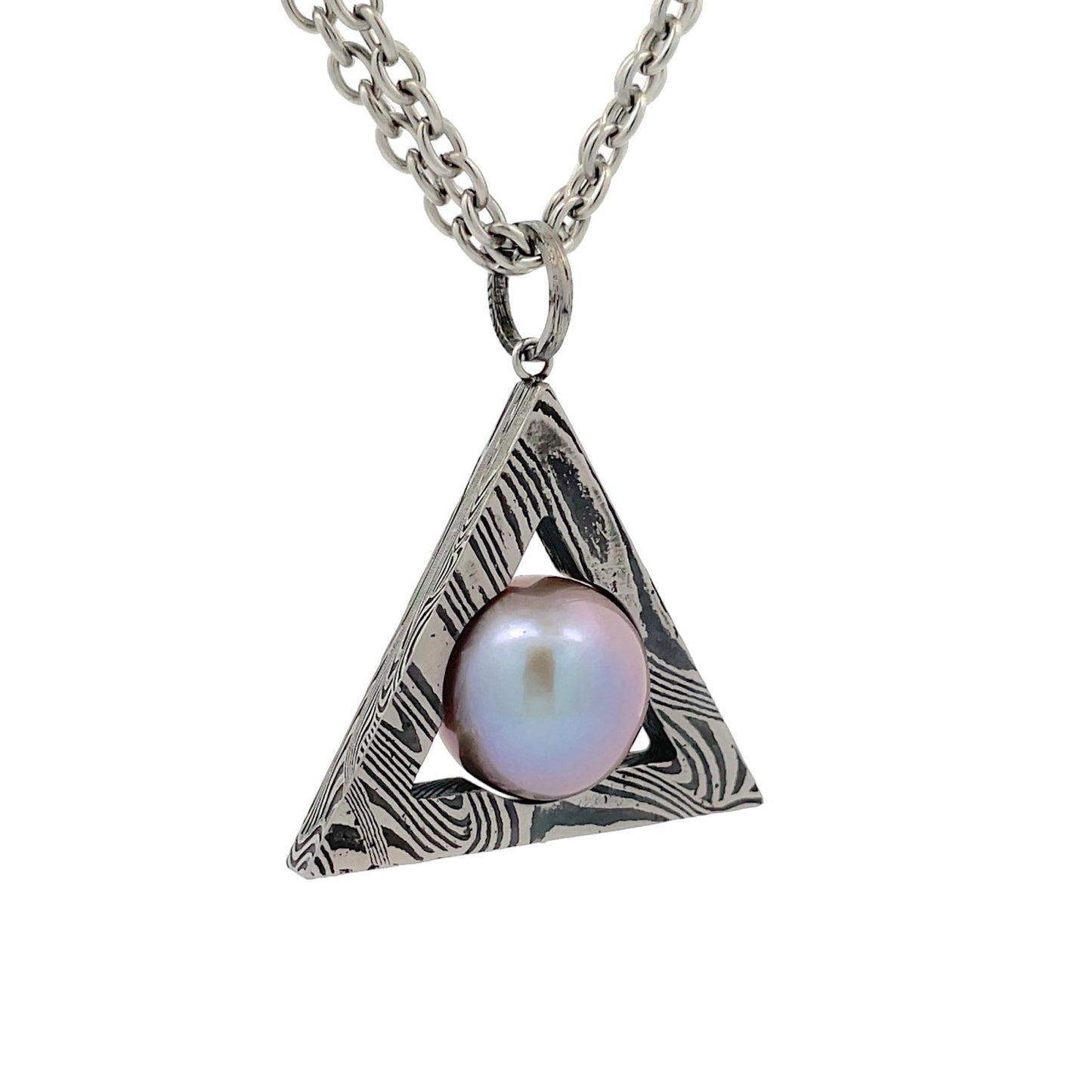 Silver triangular pendant, Damascus steel pattern, holding a pearl in the center, on a white background.