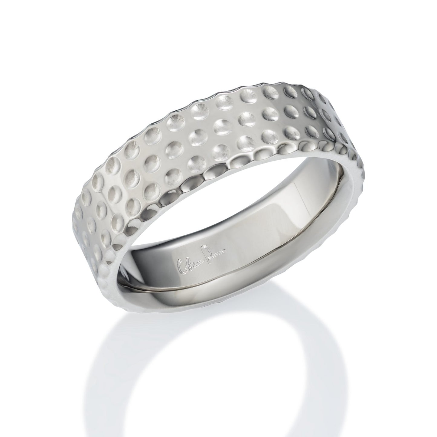 Silver ring with a textured, dome-shaped pattern resembling golf ball dimples, on a white background.