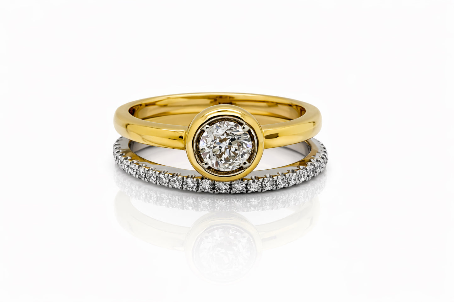 Two gold rings with diamond accents on a white background