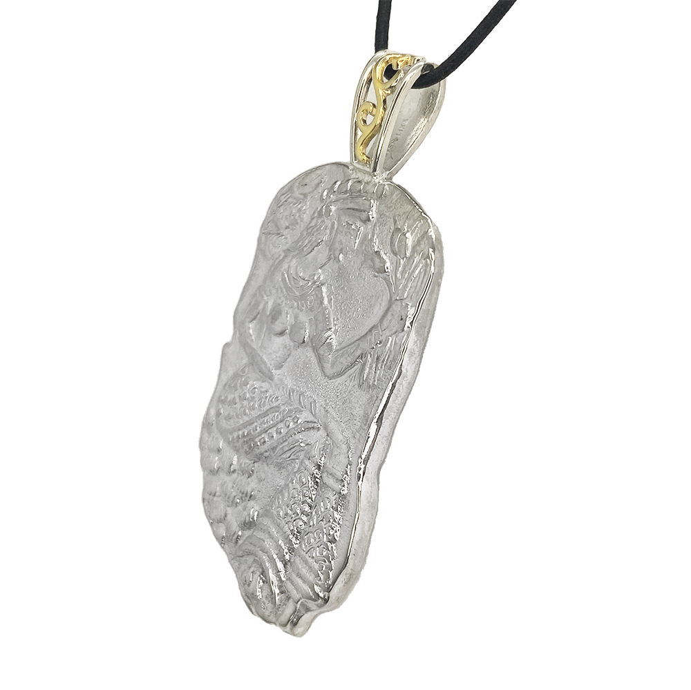 Silver pendant organic shape sculpture depicting of the Greek goddess Medusa, with gold accents on the bail.