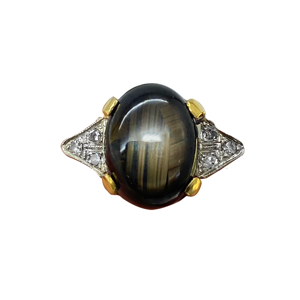 Vintage ring featuring a large oval black star sapphire with a four-rayed star pattern.