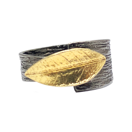  Silver ring with a textured band and a gold-plated leaf design.