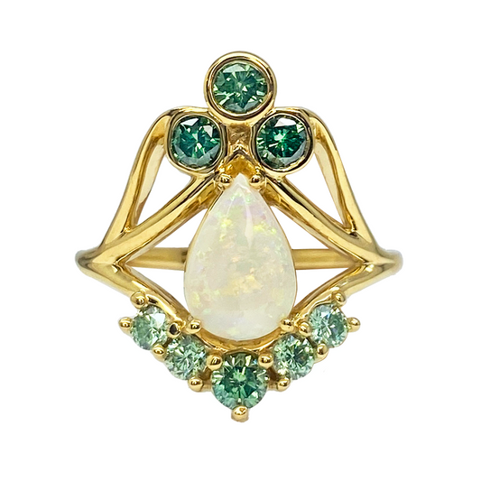  Gold ring featuring a pear-shaped opal surrounded by a cluster of green diamonds and smaller accent diamonds.