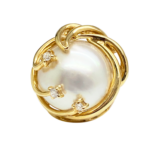 Gold ring featuring a swirling band with three accent diamonds.
