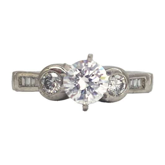 Three-stone diamond ring with a round center stone and two smaller round side stones, all set in a silver band
