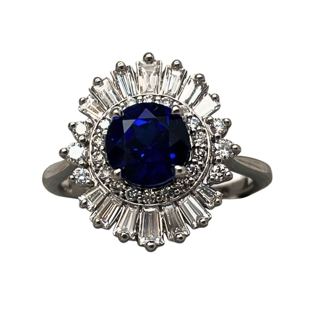 Ring with a blue gemstone and diamond accents on a white background