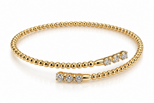 A gold beaded bracelet with three diamond-set end closures, displayed on a clean white background.