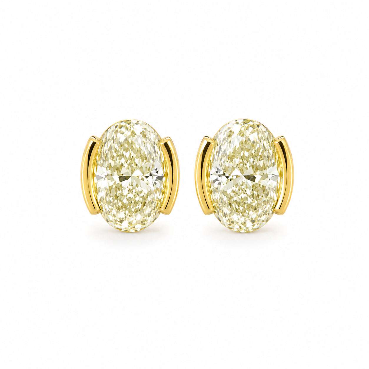 Gold earrings with large gemstones on a white background