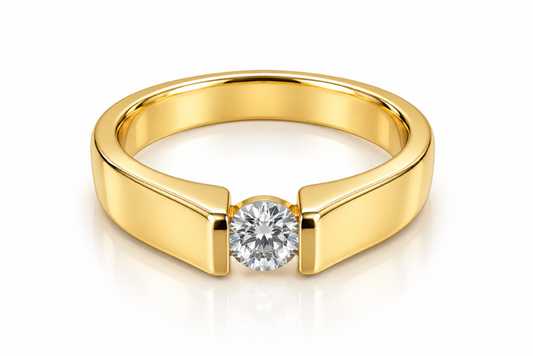 A polished yellow gold ring with a single round brilliant-cut diamond set in a bezel-like prong setting, shown on a clean white background with a soft reflection.