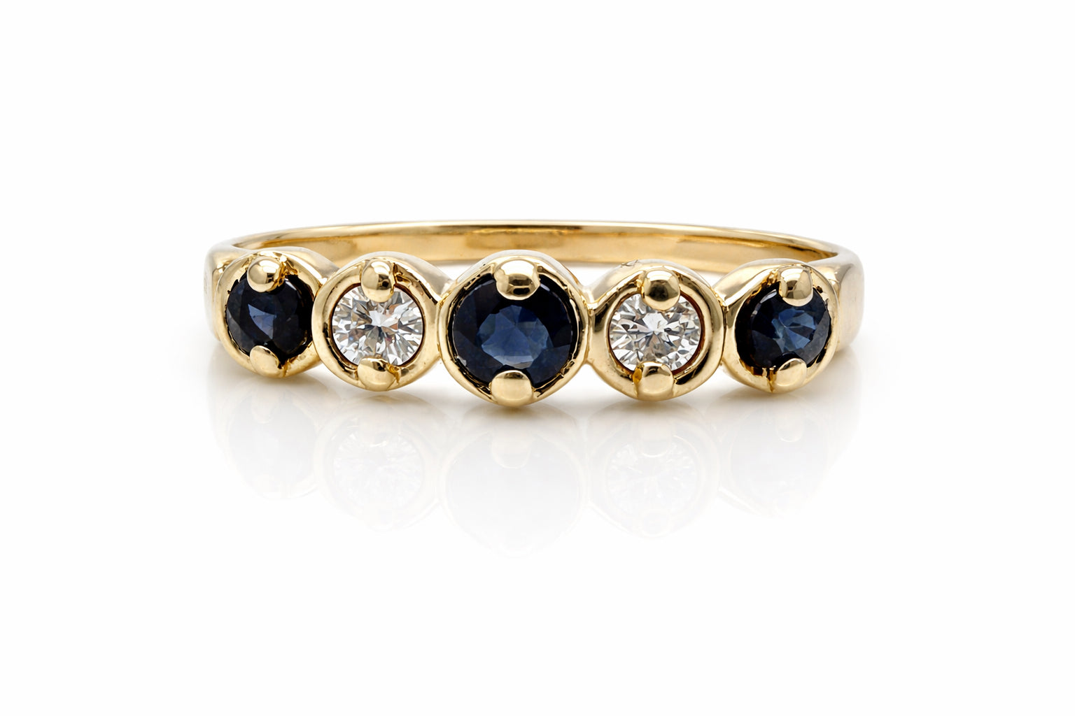 Gold ring with blue gemstones and diamonds on a white background