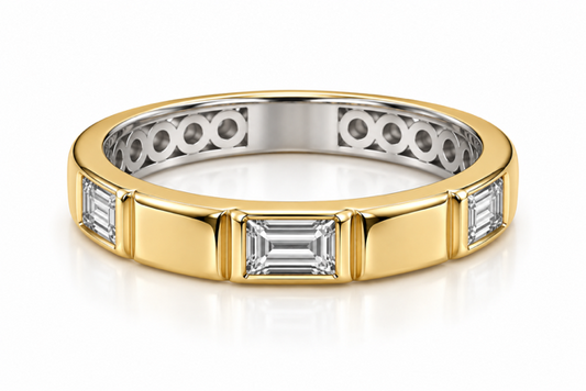 A two-tone diamond eternity ring featuring a yellow gold outer band with baguette-cut diamonds and a silver-colored inner band with round-cut diamonds, shown on a reflective white surface.
