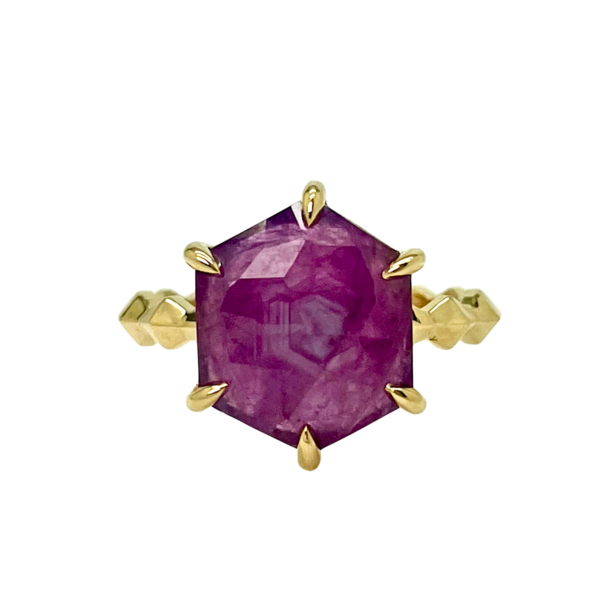 Gold ring with a ruby gemstone on a white background