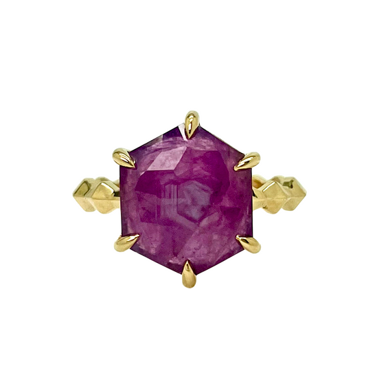 Gold ring with a ruby gemstone on a white background