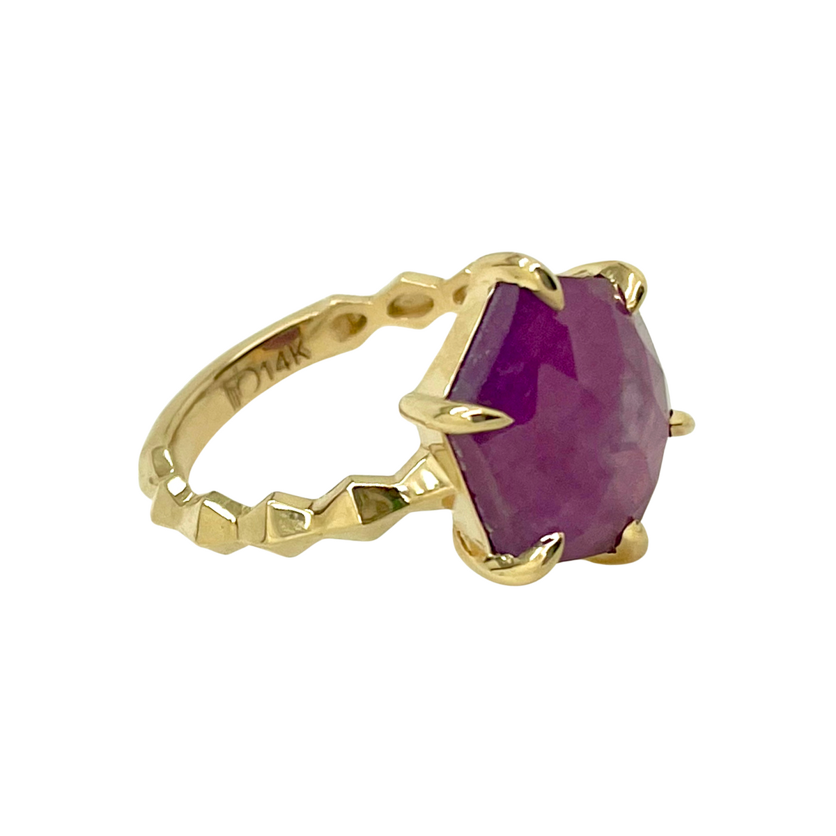 Gold ring with a ruby gemstone on a white background