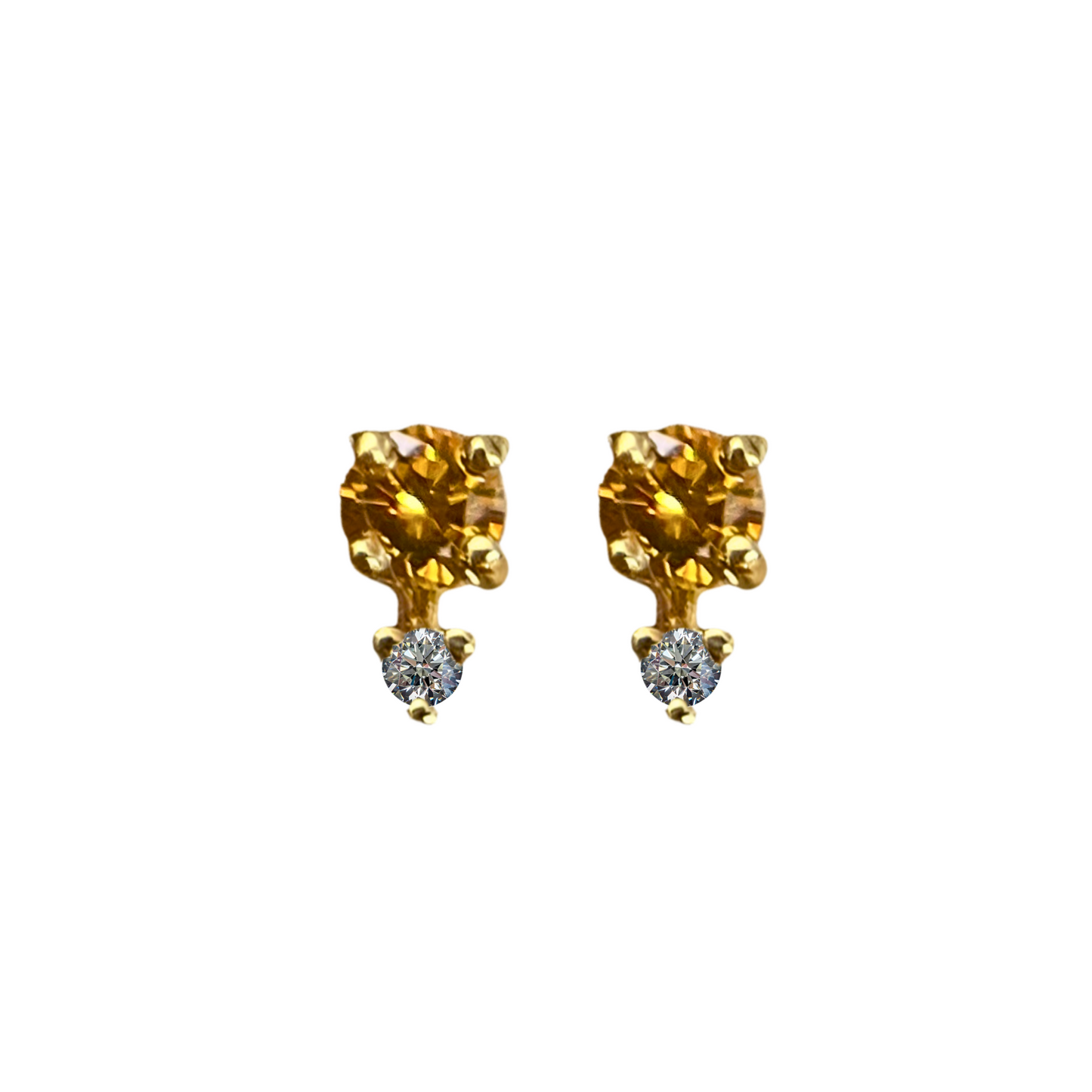 Pair of gold earrings with clear gemstones on a white background