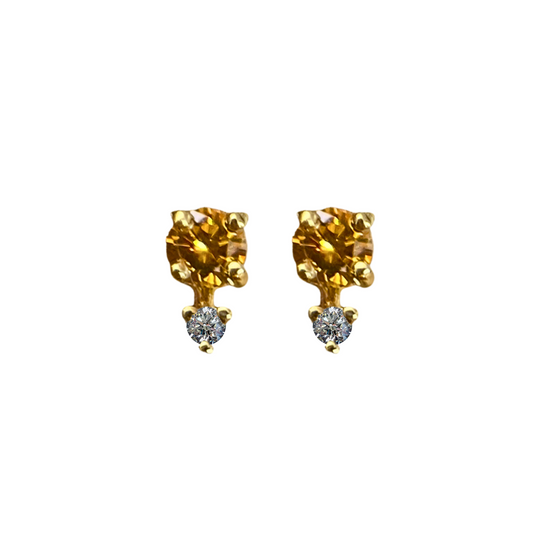 Pair of gold earrings with clear gemstones on a white background