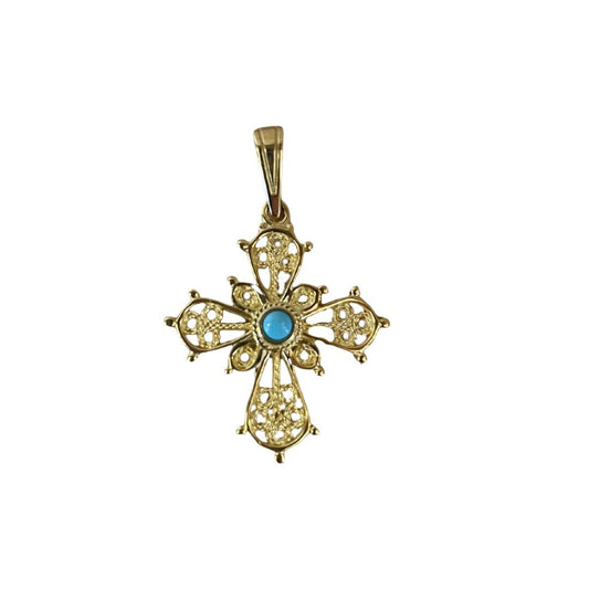 Gold cross pendant with a turquoise stone on a white background