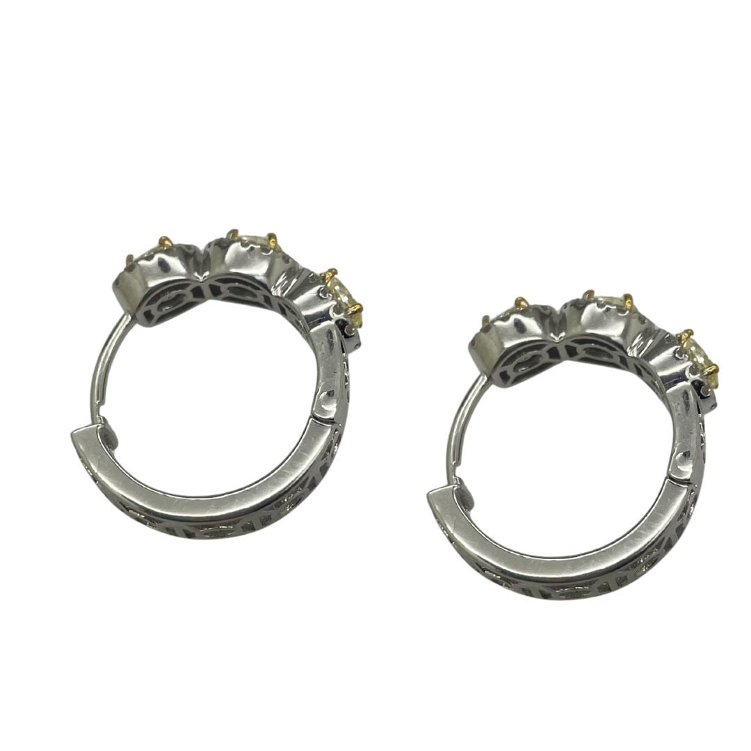Pair of silver hoop earrings with small stones on a white background