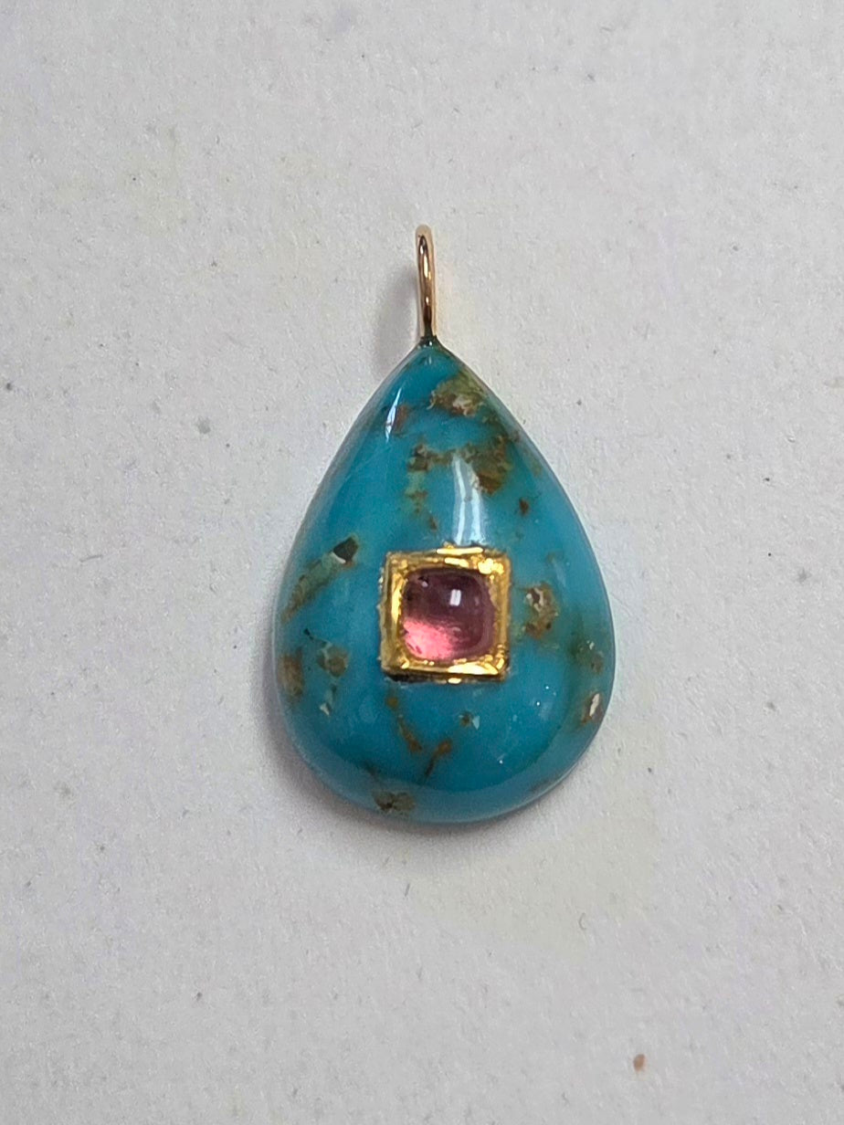 Teardrop-shaped pendant with turquoise glass and pink gemstone on a light gray background