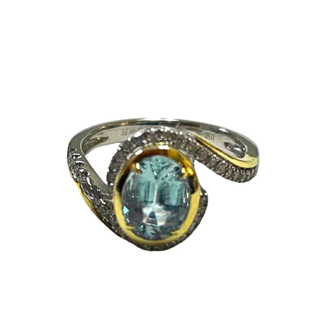 Ring with a blue gemstone and gold accents on a white background