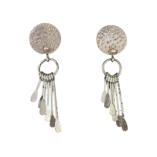 Pair of silver earrings with circular tops and dangling elements on a white background