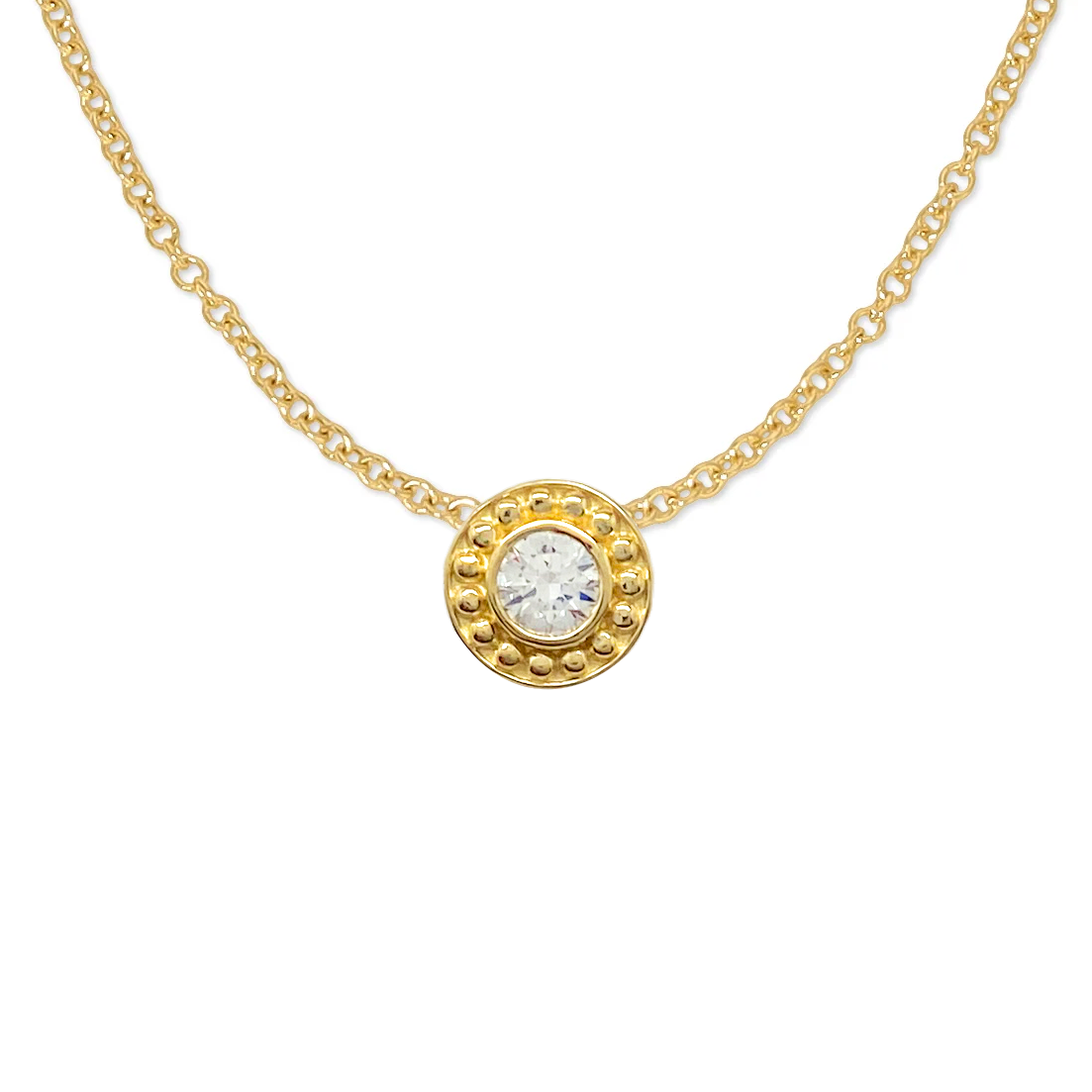 Gold necklace with a circular pendant featuring a diamond surrounded by a beaded border. The background is white.