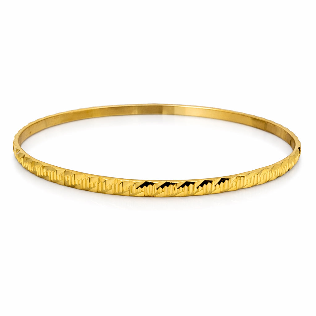 Gold bracelet with mountain design on a white background
