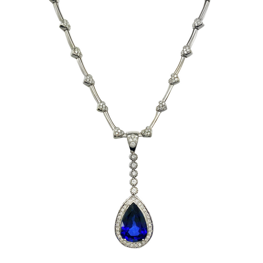 Necklace with a blue teardrop pendant and diamond accents on a white background