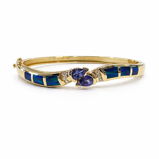 Gold bracelet with blue stones and diamonds on a white background