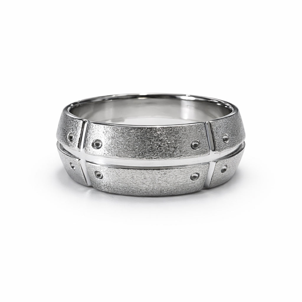 Silver ring with textured design on a white background
