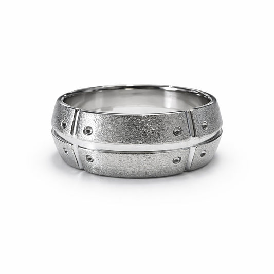 Silver ring with textured design on a white background