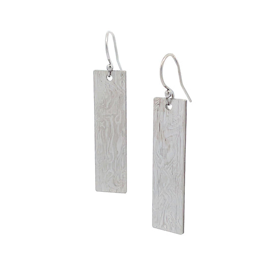 Pair of silver rectangular earrings with a textured Damascus steel on a white background.