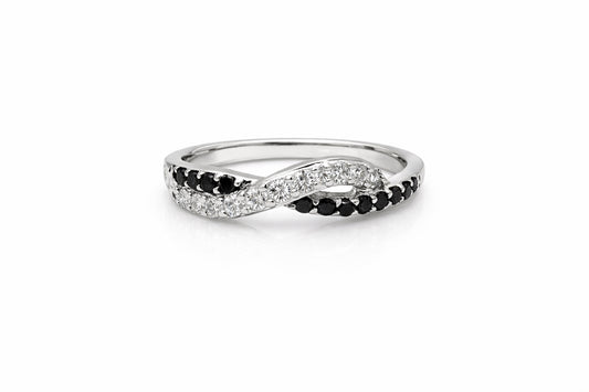 Silver ring with black and white gemstones on a white background