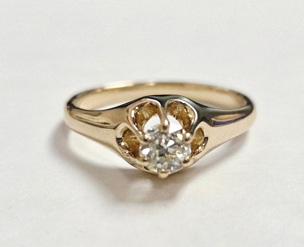 Gold ring with a diamond on a light gray background