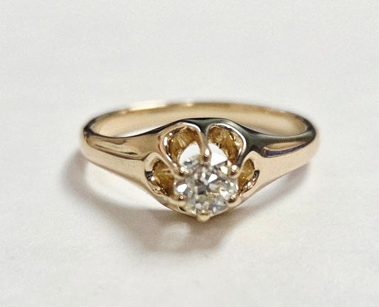 Gold ring with a diamond on a light gray background