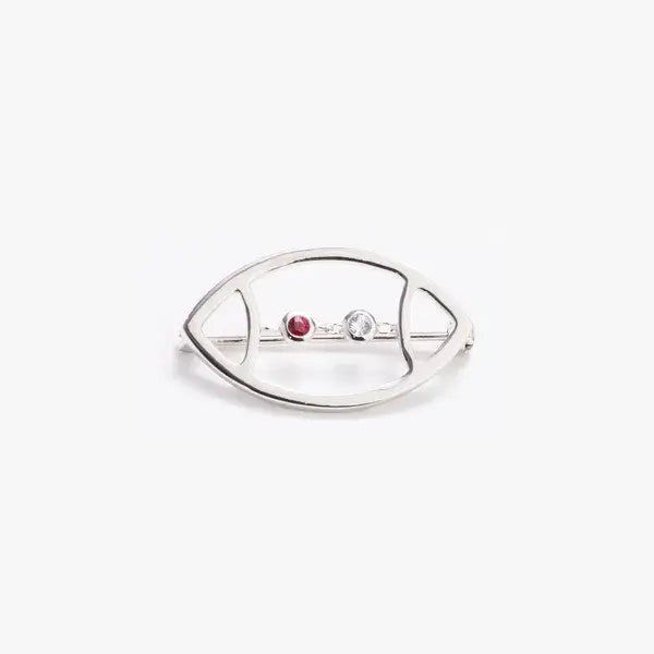 Silver brooch with red and clear gemstones on a white background