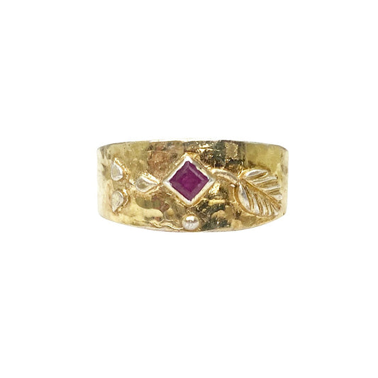 Hammered gold ring with ruby and silver accents.