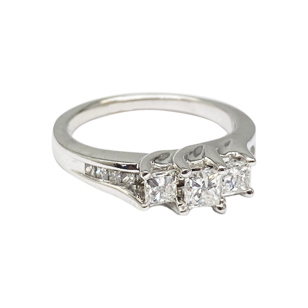 Silver three-stone diamond ring with a center princess-cut diamond flanked by two smaller princess-cut diamonds.