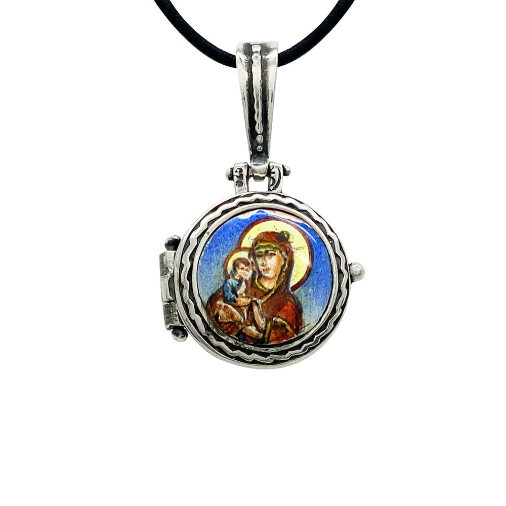 Silver locket necklace with a round pendant featuring a geometric cross design.